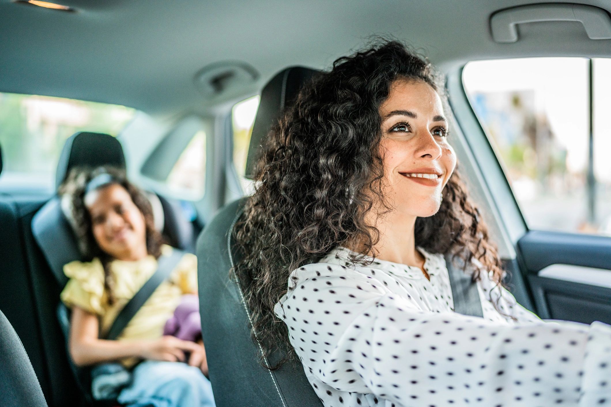 Mother and daughter talking at car